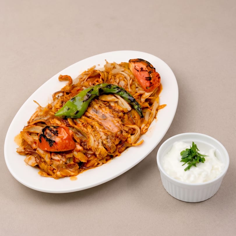 Chicken doner kebab with grilled tomatoes, green pepper, and a side of yogurt.